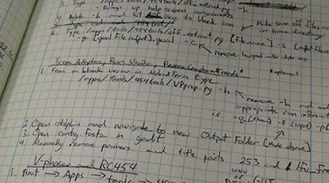 Closeup view of a biologists lab notebook. Notebook is made of grid paper and the handwriting is difficult to read.