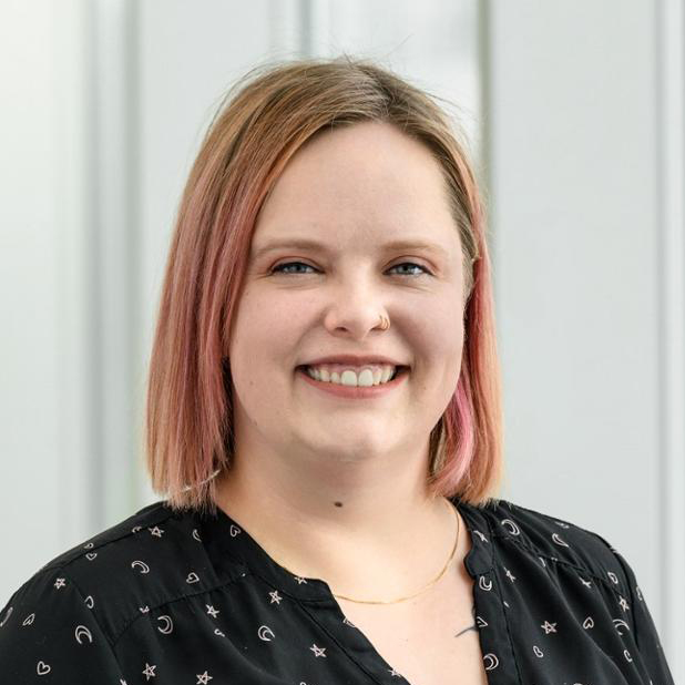 Prof. Morrison-Smith is a white woman with shoulder length pink hair. She is wearing a black patterned top